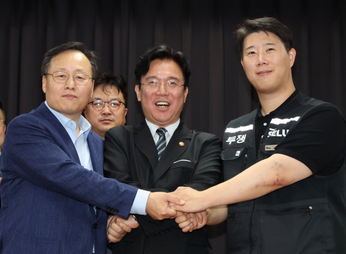 20일 경기 수원시 장안구 경기고용노동청에서 열린 삼성전자 임금협상을 마친 후 여명구 삼성전자 DS(디바이스솔루션·반도체 사업 담당) 피플팀장(왼쪽부터)과 김영훈 고용노동부 장관, 최승호 삼성그룹 초기업노동조합 삼성전자지부 위원장이 잠정 합의한에 서명한 후 손을 맞잡고 파이팅을 외치고 있다. (공동취재) 2026.05.20. photo@newsis.com /사진=뉴시스