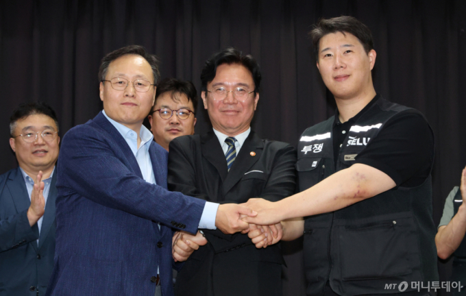 20일 경기 수원시 장안구 경기고용노동청에서 열린 삼성전자 임금협상을 마친 후 여명구 삼성전자 DS(디바이스솔루션·반도체 사업 담당) 피플팀장(왼쪽부터)과 김영훈 고용노동부 장관, 최승호 삼성그룹 초기업노동조합 삼성전자지부 위원장이 잠정 합의한에 서명한 후 손을 맞잡고 있다. /사진=뉴시스