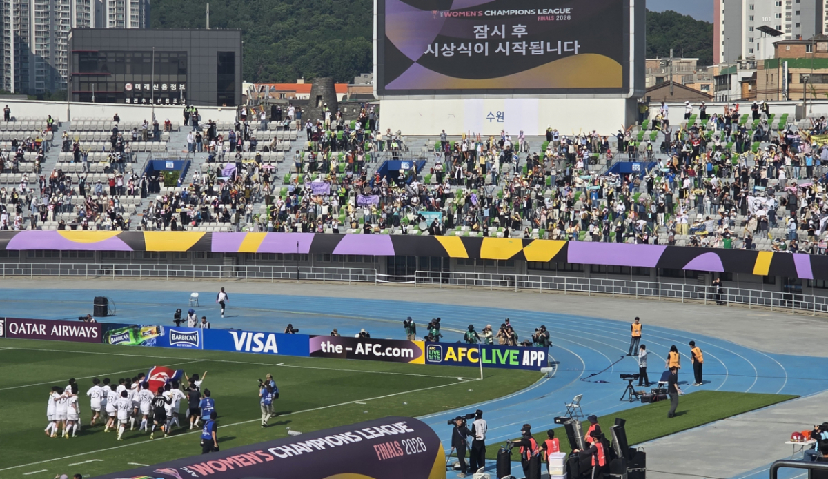북한 내고향축구선수단(왼쪽 하단)이 23일 수원종합운동장에서 열린 2025-2026 아시아축구연맹(AFC) 여자 챔피언스리그 우승 직후 인공기를 들고 경기장을 돌고 있다. 그런 내고향 선수단을 기립박수와 함성으로 맞이하고 있는 공동 응원단의 모습. /사진=김명석 기자