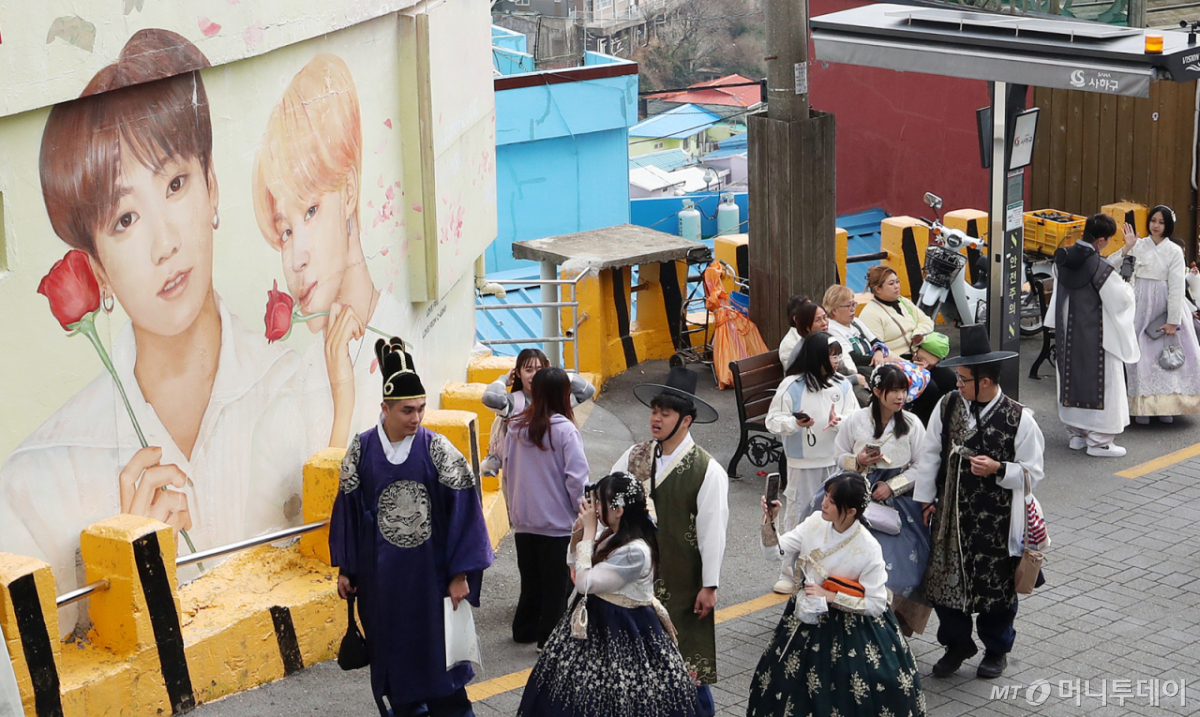 (부산=뉴스1) 윤일지 기자 = 방탄소년단(BTS) 컴백 공연을 이틀 앞둔 19일 부산 서구 감천문화마을에서 외국인 관광객들이 부산이 고향인 BTS 멤버 정국·지민이 그려진 대형 벽화를 배경으로 기념촬영을 하고 있다. 2026.3.19/뉴스1 Copyright © 뉴스1. All rights reserved. 무단 전재 및 재배포, AI학습 이용 금지. /사진=(부산=뉴스1) 윤일지 기자