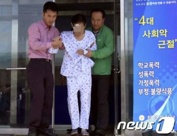 2014년 5월 28일 전남 장성군 삼계면의 효사랑요양병원에서 불을 지른 혐의(방화치사상)로 긴급체포된 A씨가 경찰들에 이끌려 장성 읍내파출소를 나오고 있다. /사진=뉴스1