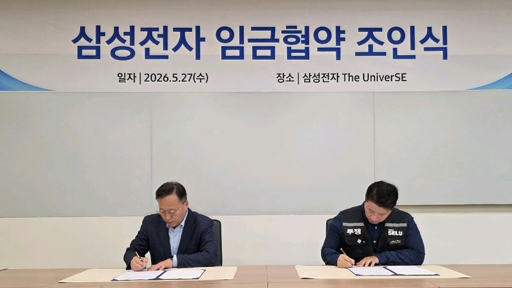 여명구 삼성전자 부사장(왼쪽)과 최승호 삼성그룹 초기업노동조합 삼성전자지부 위원장이 27일 경기 용인시 기흥 삼성전자 더유니버스(The Univer)SE에서 2026년 임금협약서에 서명하고 있다. /사진 제공=삼성전자
