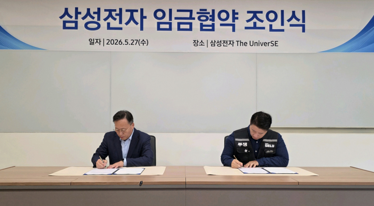 여명구 삼성전자 부사장(왼쪽)과 최승호 삼성그룹 초기업노동조합 삼성전자지부 위원장이 27일 경기 용인시 기흥 삼성전자 더유니버스(The Univer)SE에서 2026년 임금협약서에 서명하고 있다. /사진 제공=삼성전자
