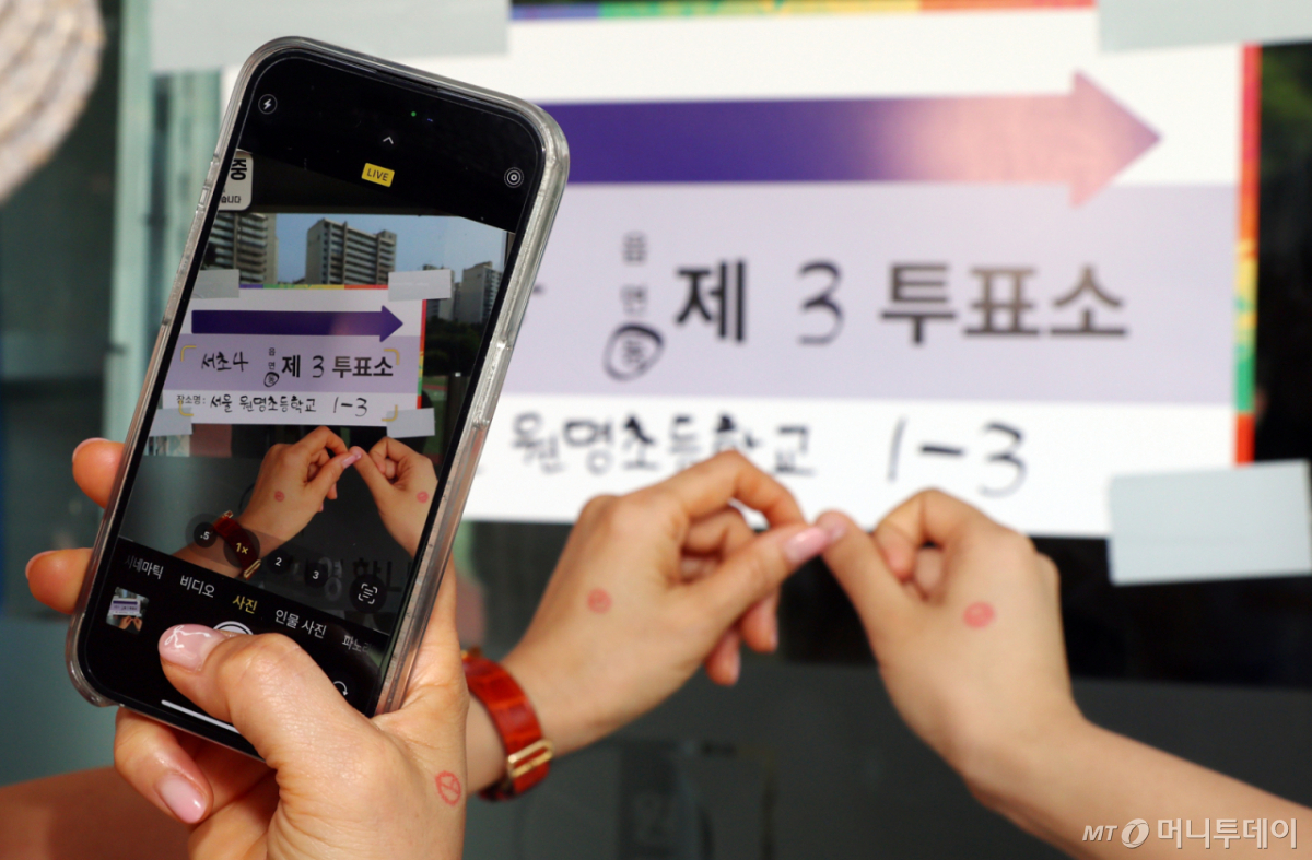제 21대 대통령 선거일인 3일 오전 서울 서초구 원명초등학교에 마련된 서초4동 제3투표소에서 시민들이 투표를 마치고 인증샷을 촬영하고 있다./사진=뉴스1