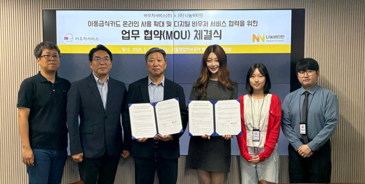 바우처서비스㈜ 박상호 대표와 ㈜나눔비타민 김하연 대표가 27일 서울창업허브 공덕에서 아동급식카드 온라인 사용 확대 및 디지털 바우처 서비스 협력을 위한 업무협약을 체결하고, 양사 관계자들과 기념촬영을 하고 있다./사진제공=나눔비타민