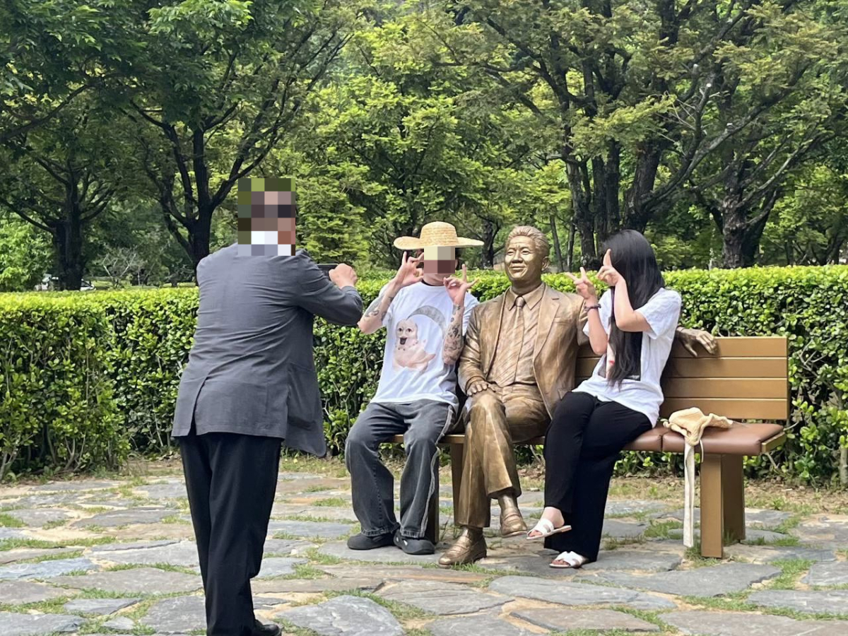 고(故) 노무현 전 대통령 17주기 추도식에서 극우 성향으로 추정되는 이용자들이 '일베'를 의미하는 손가락 포즈를 취하며 사진을 찍는 모습. /사진=조수진 변호사 페이스북 갈무리