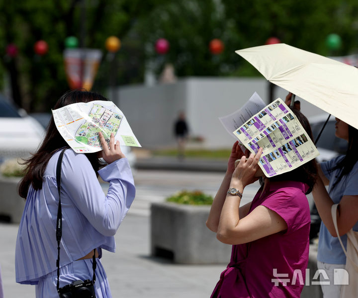 1일 기상청에 따르면 낮 기온이 30도(℃) 안팎까지 오르며 초여름 날씨를 보일 것으로 예상된다. 사진은 서울 종로구 경복궁 앞에서 시민들이 종이로 햇빛을 가리고 있는 모습./사진=뉴시스