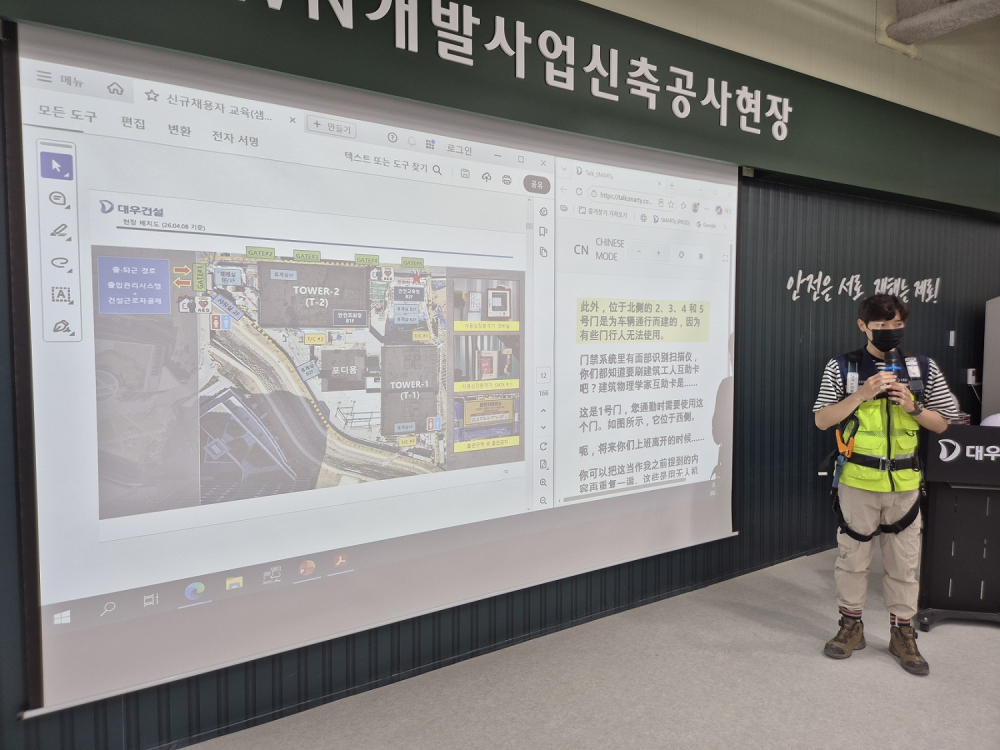대우건설 관계자가 과천 G-TOWN 개발사업 신축공사 현장에서 외국인 근로자를 위한 AI 번역기 기능에 대해 교육 중이다./사진제공=대우건설