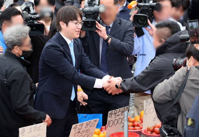 하정우 전 청와대 AI미래기획수석이 4월29일 부산 북구 구포시장에서 상인과 인사한 뒤 과일을 구입하고 있다.    하 전 수석은 전재수 더불어민주당 부산시장 후보의 지역구인 부산 북갑 보궐선거에 출마할 예정이다./사진=뉴시스