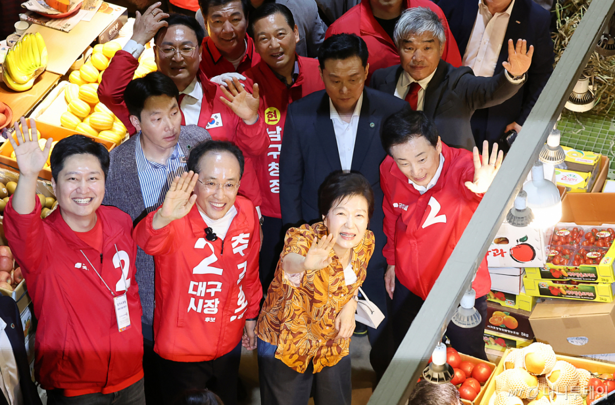  박근혜 전 대통령이 23일 오후 대구 북구 칠성시장을 찾아 추경호 국민의힘 대구시장 후보 등 일행과 함께 이동하며 손을 흔들고 있다. /사진=뉴스1