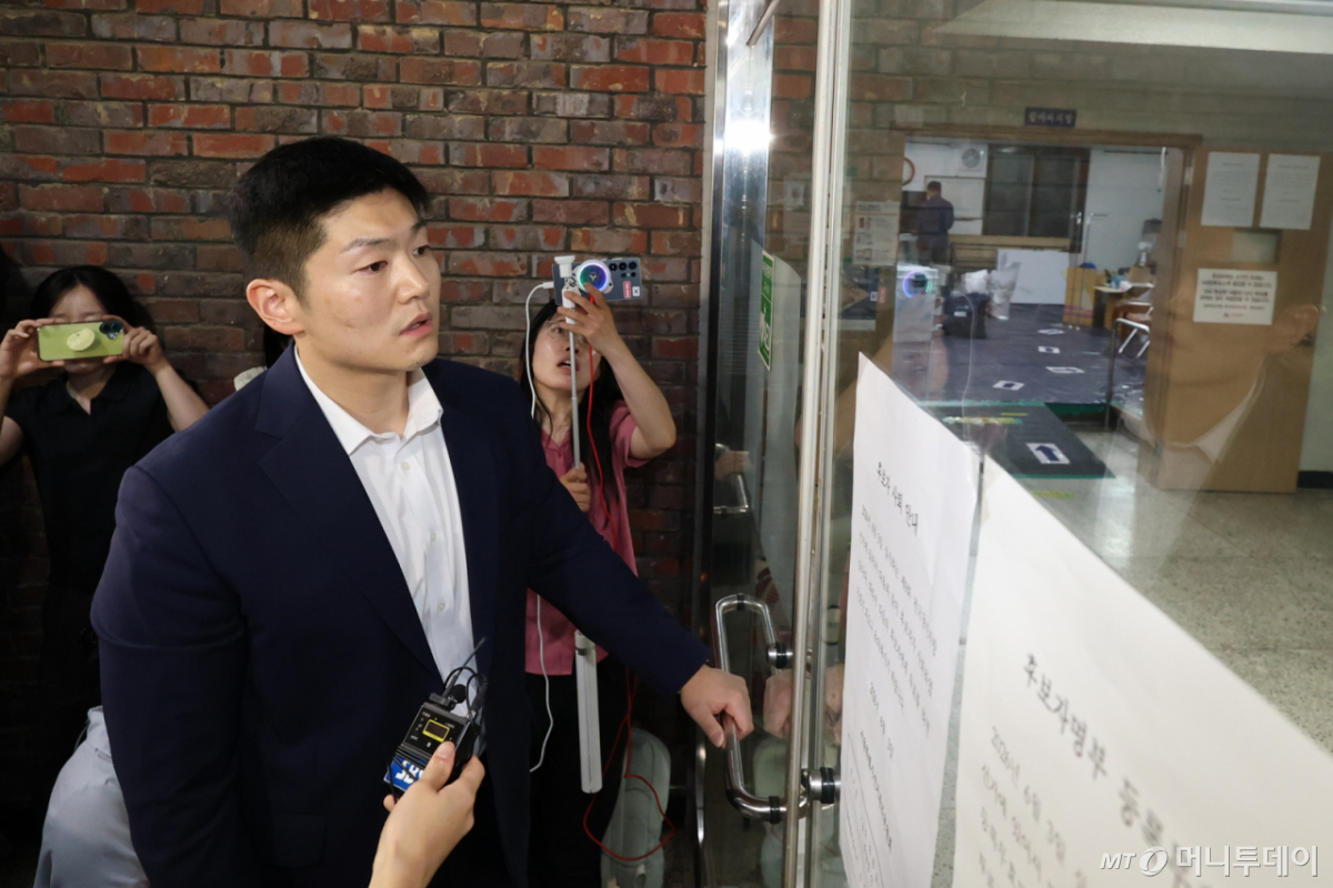 (서울=뉴스1) 박지혜 기자 = 제9회 전국동시지방선거 및 국회의원 재·보궐선거 본투표일인 3일 투표용지 부족으로 투표 시간이 오후 10시까지 연장된 서울 송파구 잠실7동 제2투표소를 찾은 김재섭 국민의힘 의원이 닫힌 출입문 손잡이를 잡고 있다. 2026.6.4/뉴스1 Copyright © 뉴스1. All rights reserved. 무단 전재 및 재배포, AI학습 이용 금지. /사진=(서울=뉴스1) 박지혜 기자