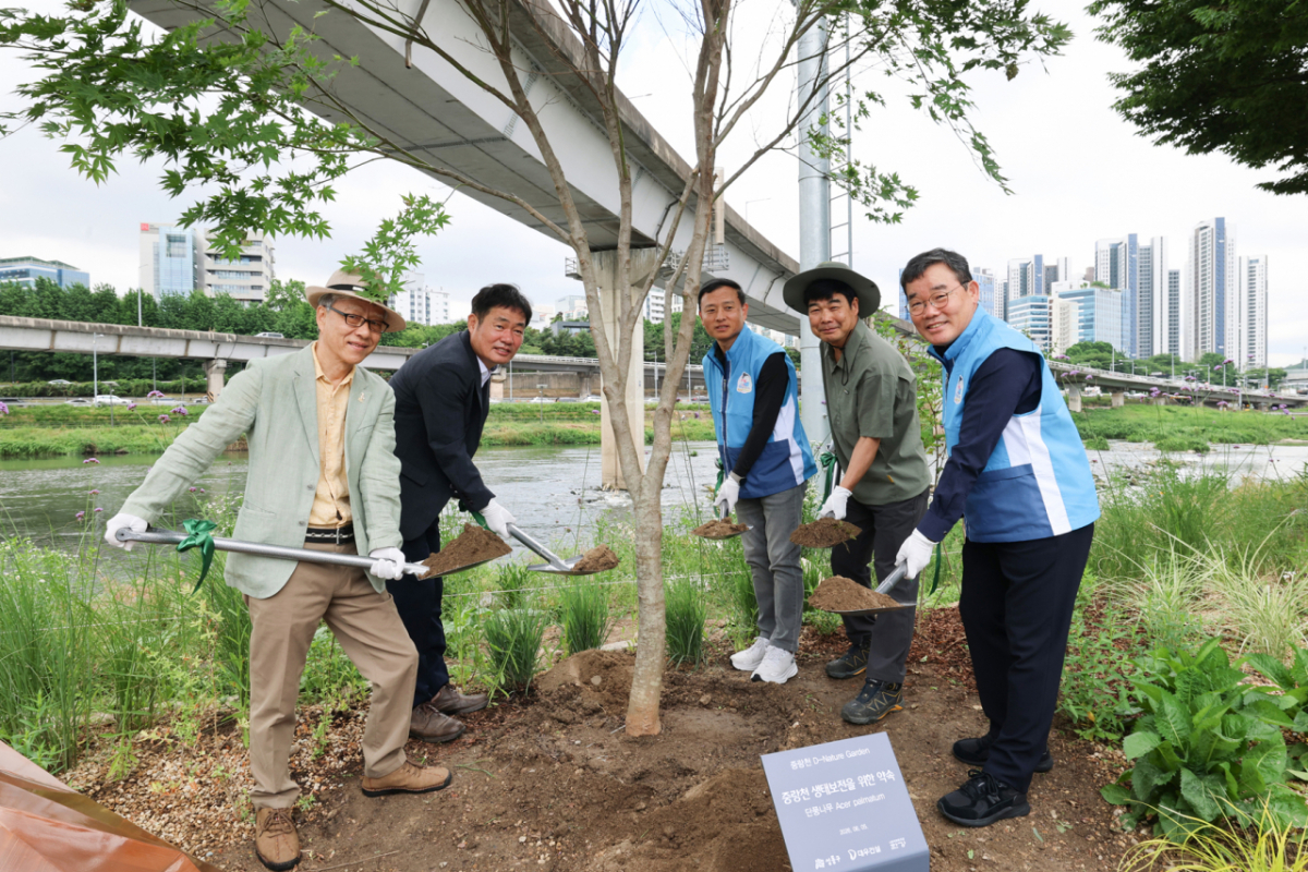 김보현 대우건설 대표이사(오른쪽 첫번째)와 고광현 성동구 부구청장(왼쪽에서 두번째)이 지난 5일 서울 성동구 중랑천 일대에서 환경의 날 기념 식수 행사를 진행하고 있다./사진제공=대우건설