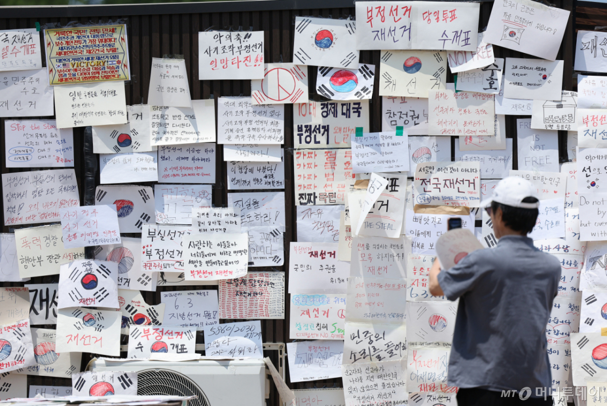 (서울=뉴스1) 김성진 기자 = 제9회 전국동시지방선거 투표용지 부족 사태에 반발한 시민들이 9일 서울 송파구 올림픽공원 핸드볼경기장에 설치된 개표소 앞에 피켓이 붙여져 있다. 2026.6.9/뉴스1 Copyright © 뉴스1. All rights reserved. 무단 전재 및 재배포, AI학습 이용 금지. /사진=(서울=뉴스1) 김성진 기자