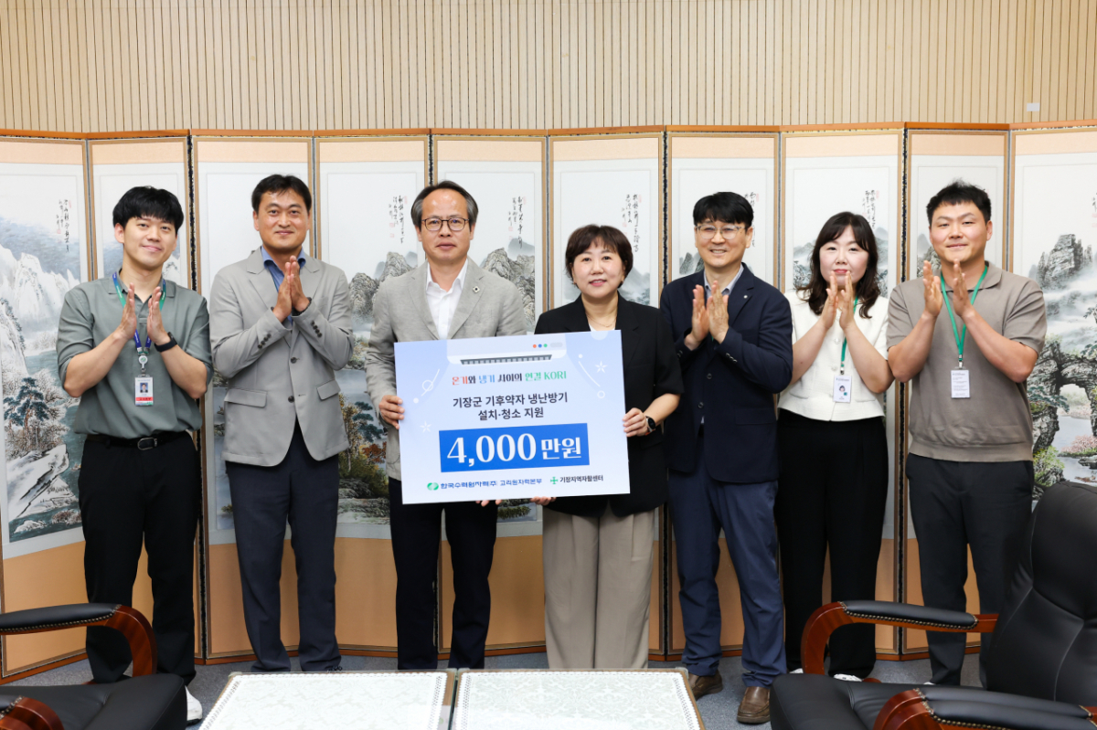 남영규 고리원자력본부 대외협력처장(왼쪽에서 3번째)이 이선주 기장지역자활센터장(가운데)에게 지원금을 전달하고 있다./사진제공=고리원자력본부