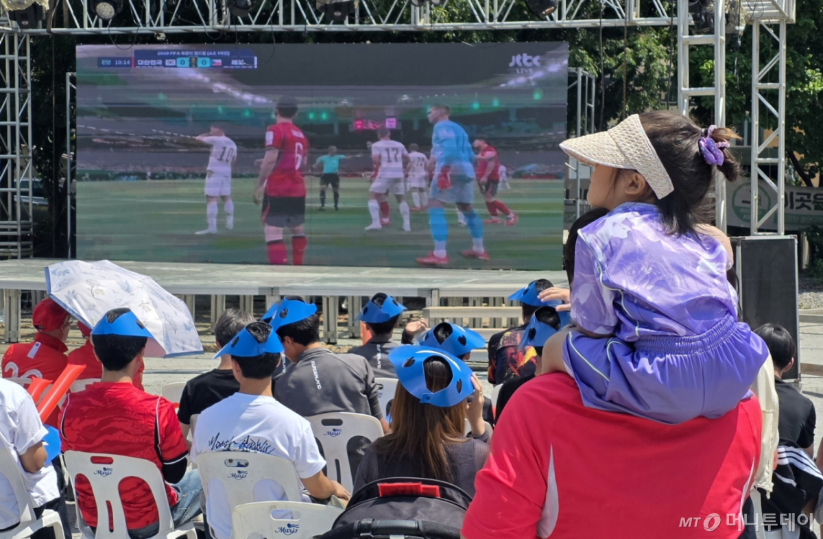 (천안=뉴스1) 이시우 기자 = '2026 FIFA 월드컵' 대한민국 대표팀 첫 경기가 열린 12일 충남 천안시 동남구 신부동 홍익스포츠타운 주차장에 마련된 단체 응원장에서 문유빈 양(5)이 아버지의 목말을 타고 응원하고 있다.  2026.6.12/뉴스1  Copyright © 뉴스1. All rights reserved. 무단 전재 및 재배포,  AI학습 이용 금지. /사진=(천안=뉴스1) 이시우 기자