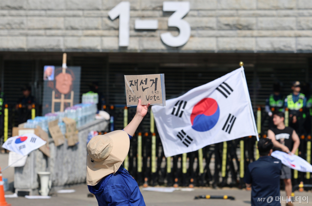 (서울=뉴스1) 오대일 기자 = 제9회 전국동시지방선거 투표용지 부족 사태를 규탄하는 개표소 봉쇄 시위가 계속된 11일 서울 송파구 올림픽공원 핸드볼경기장 앞에서 시위대가 재선거를 요구하는 피켓을 들고 있다. 2026.6.11/뉴스1 Copyright © 뉴스1. All rights reserved. 무단 전재 및 재배포, AI학습 이용 금지. /사진=(서울=뉴스1) 오대일 기자