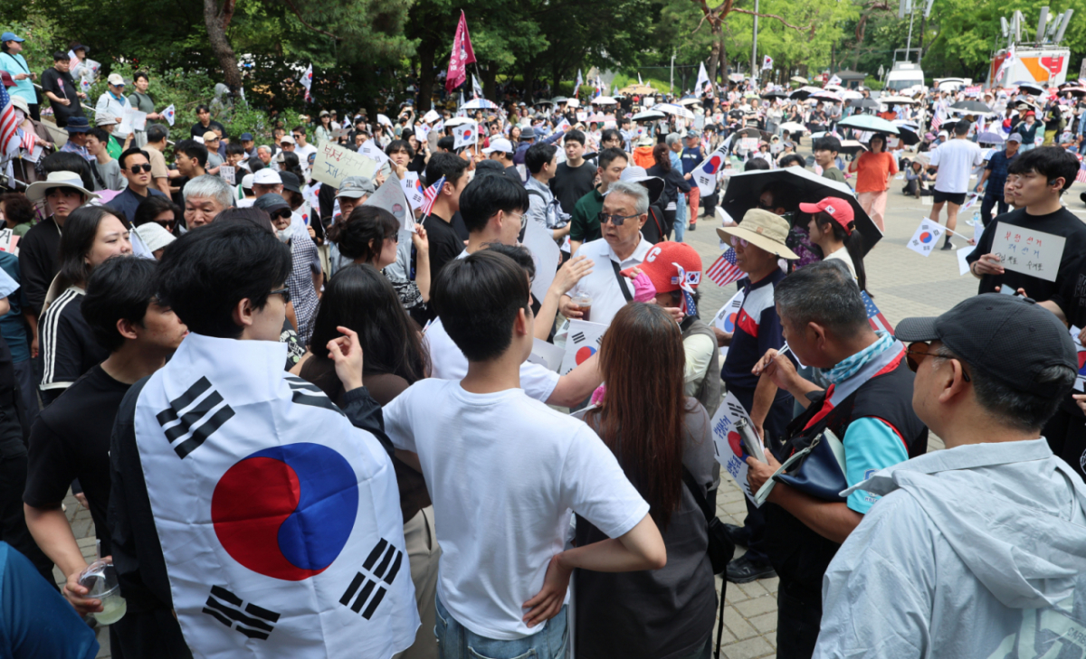 제9회 전국동시지방선거 투표용지 부족 사태에 항의하며 개표소 봉쇄 시위를 이어가고 있는 10일 서울 송파구 올림픽공원 핸드볼경기장에 설치된 개표소 앞에서 시민과 경찰이 대치상황이 벌어질뻔 하자 청년들이 이를 제지하고 있다./사진=뉴시스.