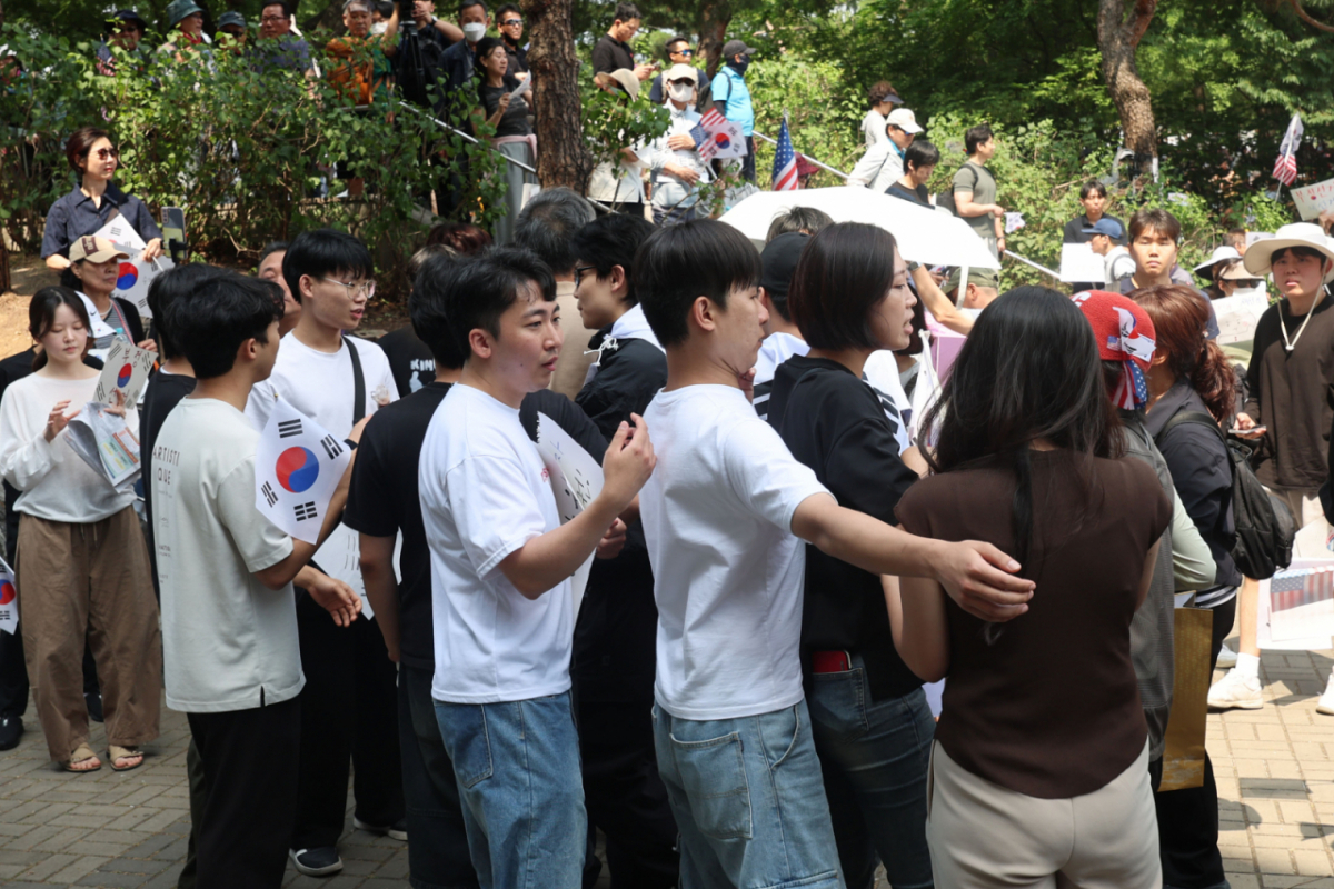 제9회 전국동시지방선거 투표용지 부족 사태에 항의하며 개표소 봉쇄 시위를 이어가고 있는 10일 서울 송파구 올림픽공원 핸드볼경기장에 설치된 개표소 앞에서 시민과 경찰이 대치상황이 벌어질뻔 하자 청년들이 이를 제지하고 있다./사진=뉴시스.