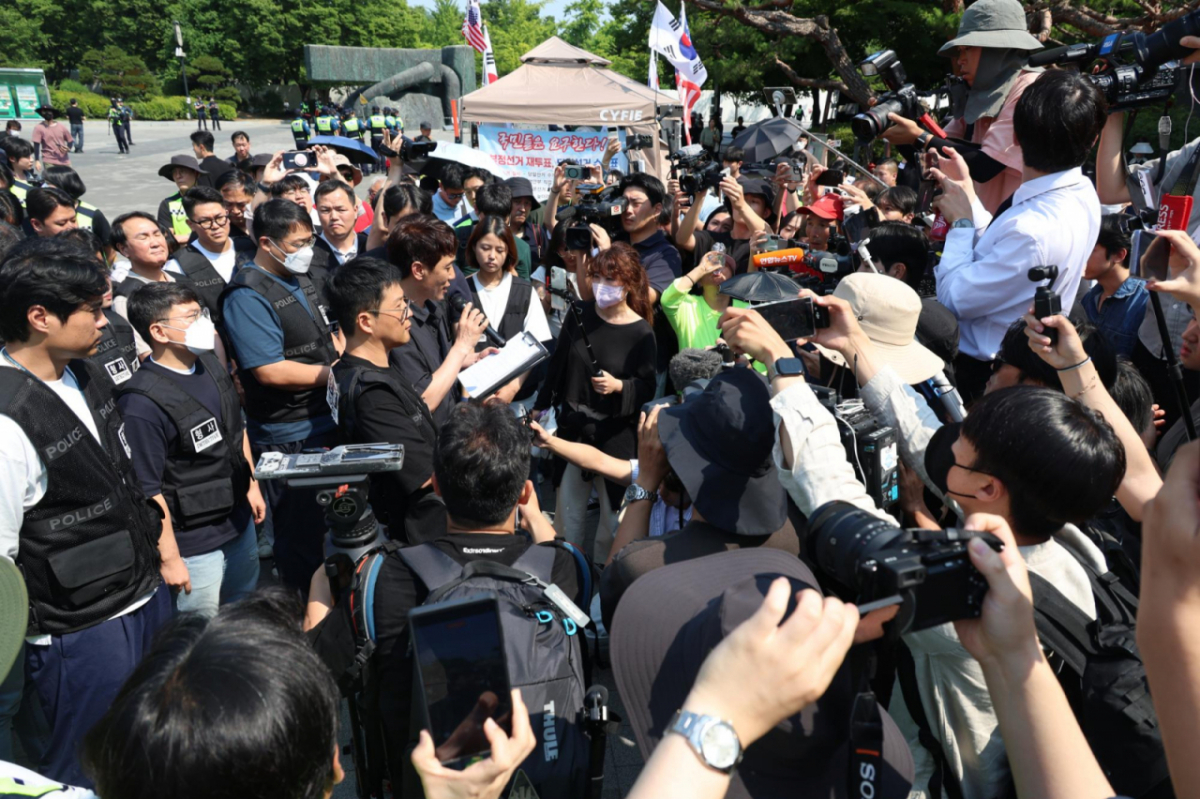 6·3 지방선거 투표용지 부족 사태를 규탄하는 개표소 봉쇄 시위가 이어진 16일 서울 올림픽공원 핸드볼경기장 앞에서 경찰이 시위대에게 입주단체 등 출입 관련 경고를 고지하고 있는 모습./사진=뉴시스.
