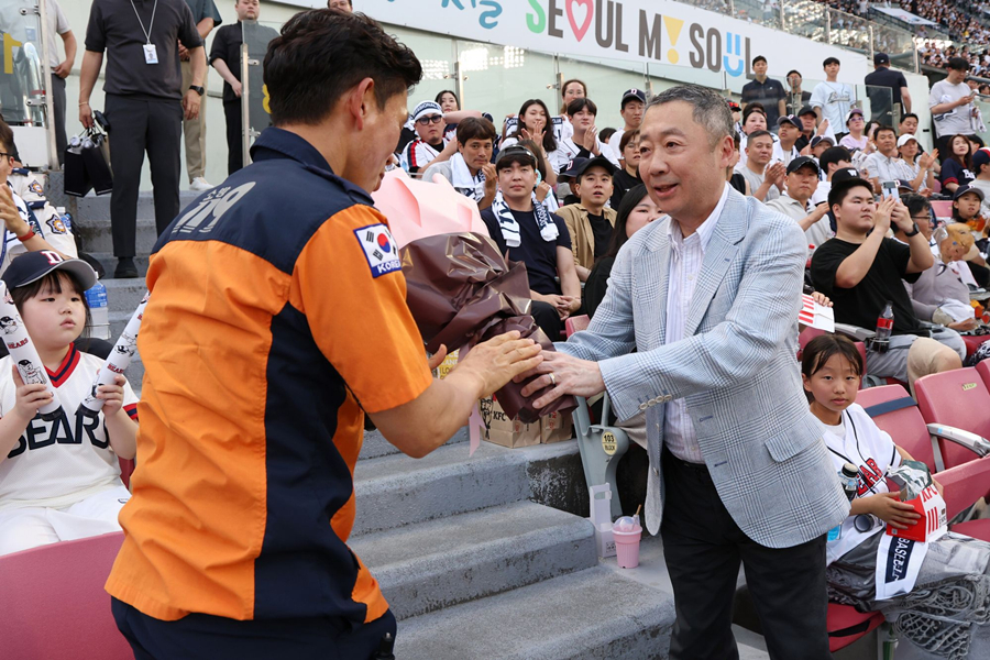 박정원(오른쪽) 회장이 2024년 6월 19일 '두산베어스 소방가족의 날'을 맞아 서울119 특수구조단 한정민 팀장에게 꽃다발을 건네고 있다. /사진=두산 베어스