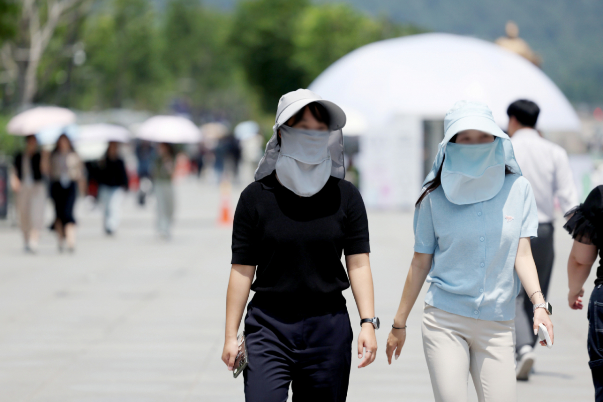 전국 대부분 지역에서 낮 기온이 30도 이상으로 오르며 무더운 날씨가 이어지고 있는 지난 16일 서울 종로구 광화문광장에서 시민들이 모자와 마스크로 햇빛을 피하고 있다. /사진=뉴시스.