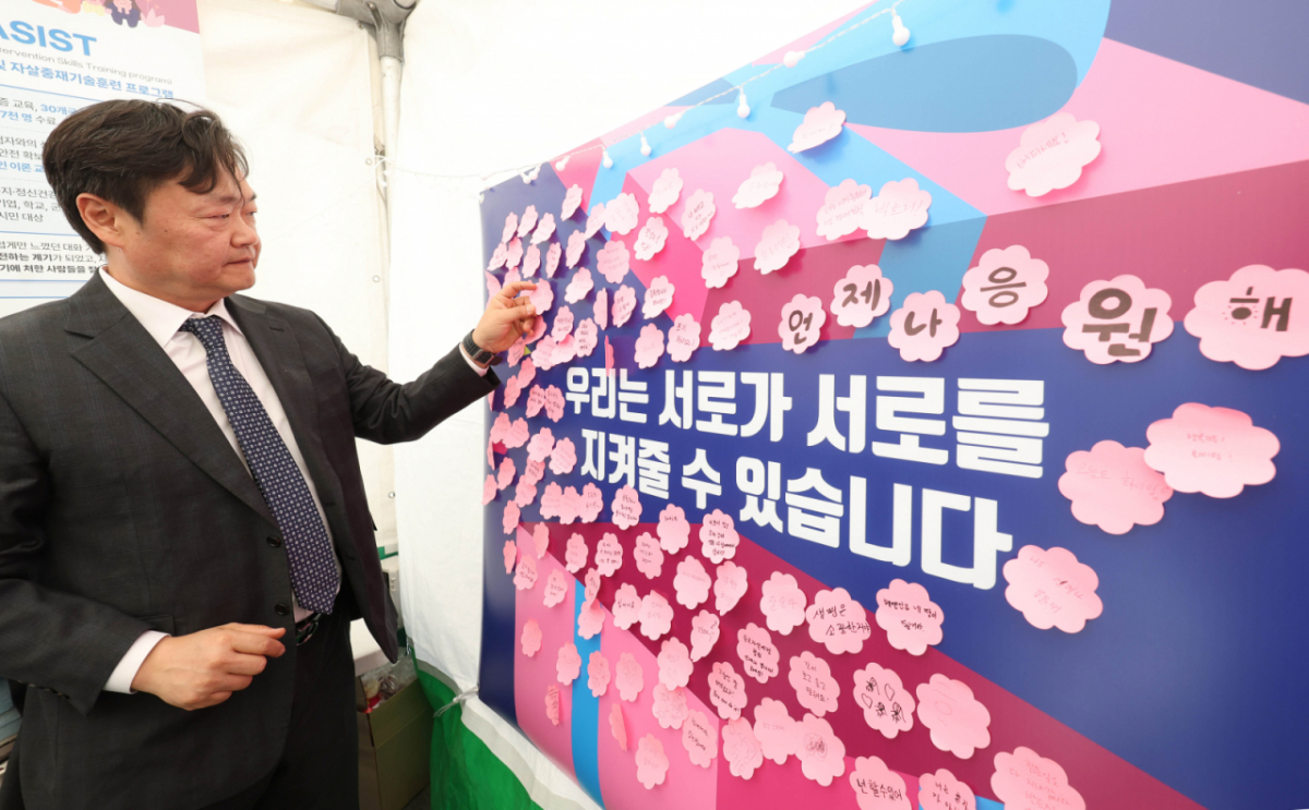 백종우 한국자살예방협회 회장이 지난4월24일 오전 서울 종로구 청계광장에 마련된 한국자살예방협회 '천명지킴 발대식' 부스에서 응원 문구를 작성해 붙이고 있다. /사진=뉴시스.