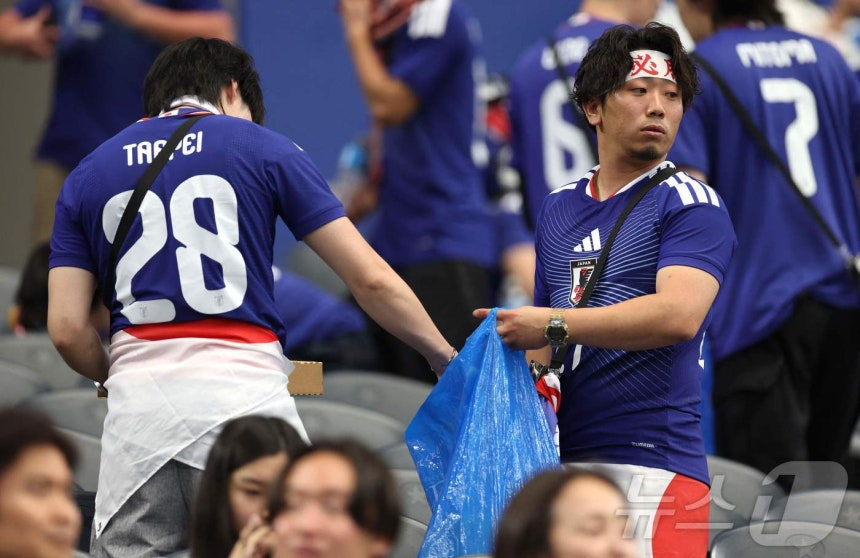 일본 남성 축구 팬들이 2026 국제축구연맹(FIFA) 북중미 월드컵에서 경기 후 관중석 쓰레기를 치우는 모습./사진=AFP=뉴스1