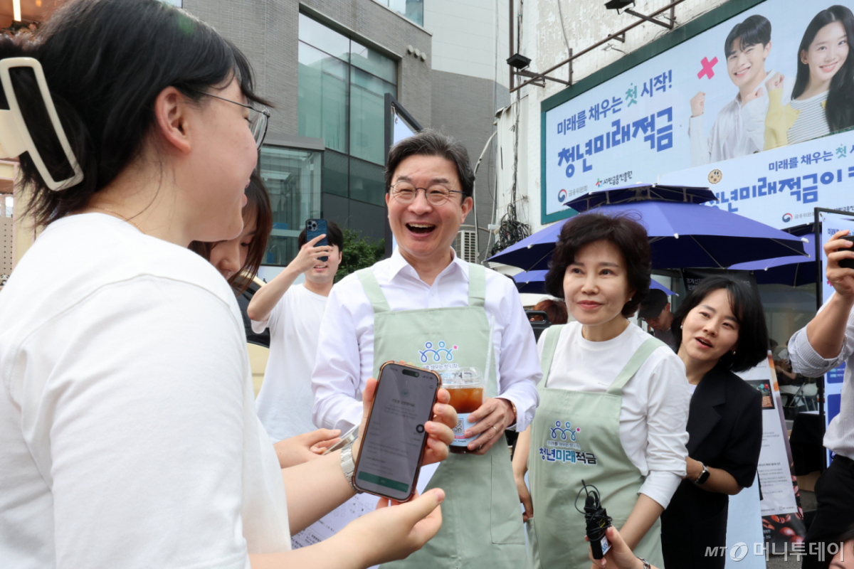 [서울=뉴시스] 조성우 기자 = 이억원(가운데) 금융위원회 위원장이 22일 서울 성동구 뚝섬역 인근에서 열린 청년미래적금 출시 기념행사에서 시민에게 커피를 건네며 청년미래적금을 홍보하고 있다. 2026.06.22. xconfind@newsis.com /사진=조성우