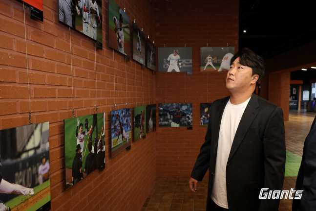 정훈이 26일 부산 LG전을 앞두고 열린 자신의 은퇴식에서 개최된 현역 시절 사진을 관람하고 있다. /사진=롯데 자이언츠 제공