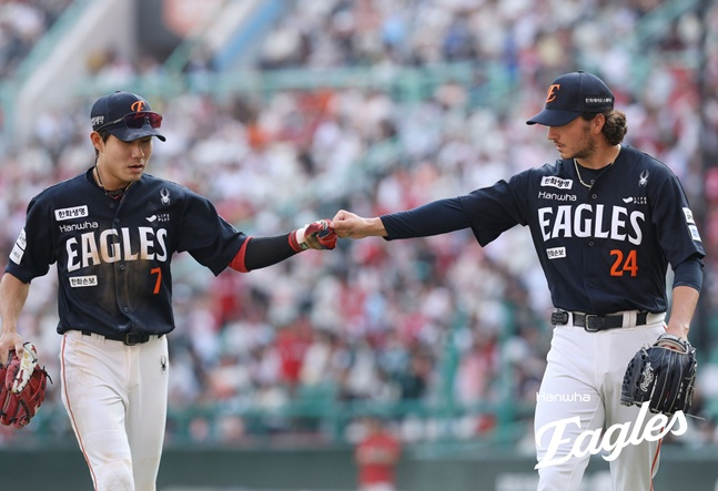 한화 이글스 투수 오웬 화이트(오른쪽)가  27일 인천 SSG랜더스필드에서 열린 SSG 랜더스와 2026 신한 SOL KBO리그 방문경기에서 수비의 도움으로 이닝을 마친 뒤 심우준과 하이파이브를 하고 있다. /사진=한화 이글스 제공