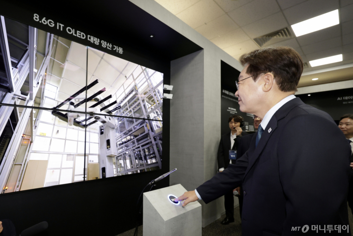 [아산=뉴시스] 최동준 기자 = 이재명 대통령이 2일 충남 아산시에서 열린 충청권  첨단산업 발전비전 국민보고회에서 삼성디스플레이의 주요 제품을 관람하며 유리 기판을 라인에 투입하는 버튼을 터치하고 있다.이 유리 기판은 세계 최초 8.6세대 OLED 디스플레이 양산을 위한 첫 투입이다. 2026.07.02. photocdj@newsis.com /사진=최동준