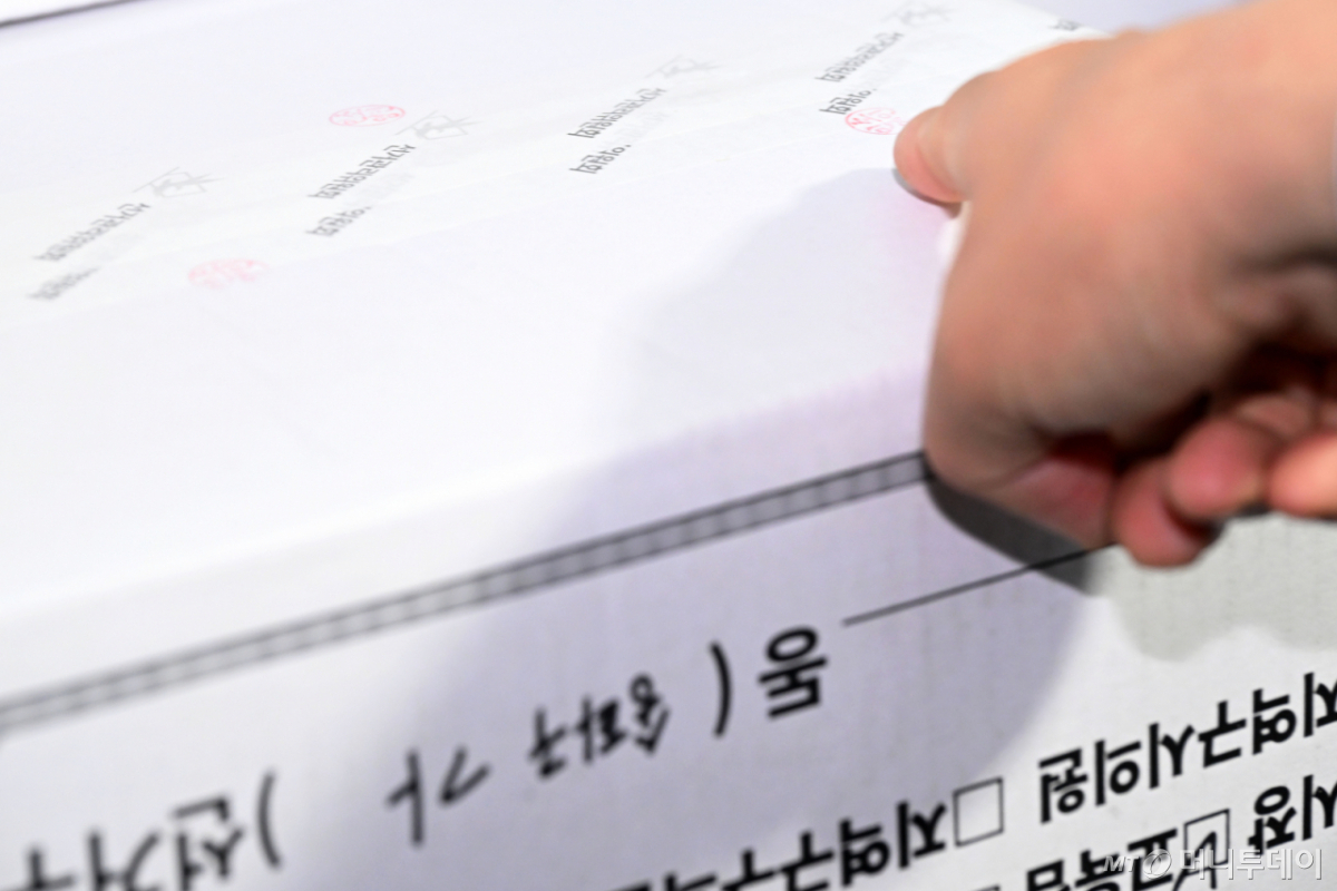 (서울=뉴스1) 국회사진기자단 = 국회 전국동시지방선거 투표용지 부족 사태 등 국민 참정권 침해 진상규명 및 선거관리 개혁을 위한 국정조사 특별위원회가 현장 조사에 나선 2일 서울 송파구 올림픽공원 핸드볼경기장에서 선거관리위원회 관계자가 투표지 보관 박스에 찍힌 도장을 가리키고 있다. 2026.7.2/뉴스1  Copyright © 뉴스1. All rights reserved. 무단 전재 및 재배포,  AI학습 이용 금지. /사진=(서울=뉴스1) 국회사진기자단