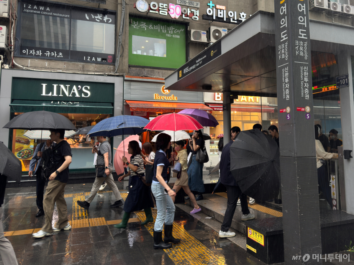 8일 오전 8시쯤 서울 영등포구 여의도역 5번 출구에 시민들이 우산을 쓰고 출근하고 있다./사진=최문혁 기자.
