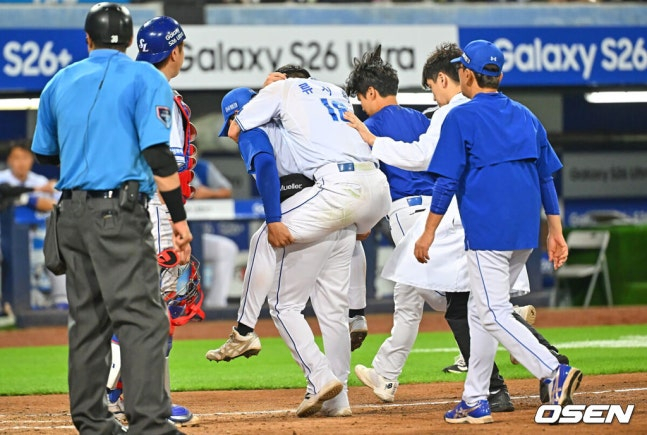 삼성 류지혁이 8일 대구 LG전 6회초 무사 2루에서 코치에게 업혀 그라운드를 떠나고 있다.
