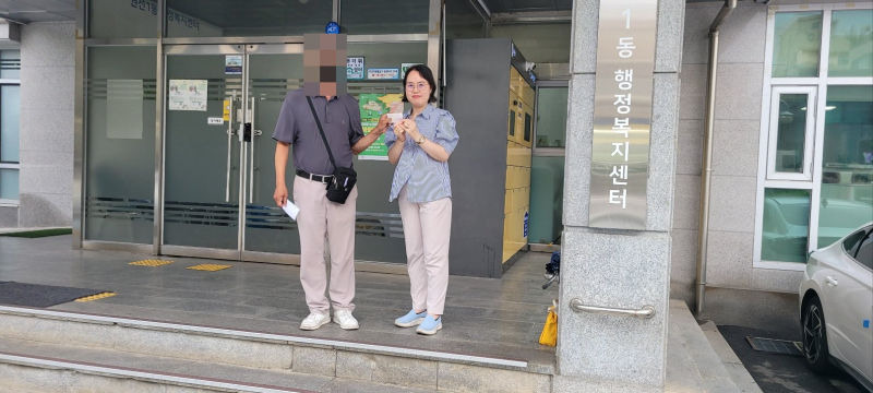 지난 6월 동행정복지센터에서 주민등록증을 발급받은 강OO씨가 김경숙 베테랑팀장과 주민등록증을 들고 있다./사진제공=수원시