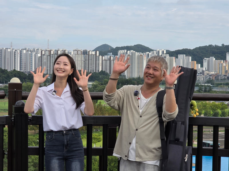 김시영 시흥시 문화홍보대사(오른쪽)와 이우현 아나운서가 갯골생태공원 흔들전망대 위에서 버스킹 엔딩 장면을 촬영하고 있다./사진=이민호기자
