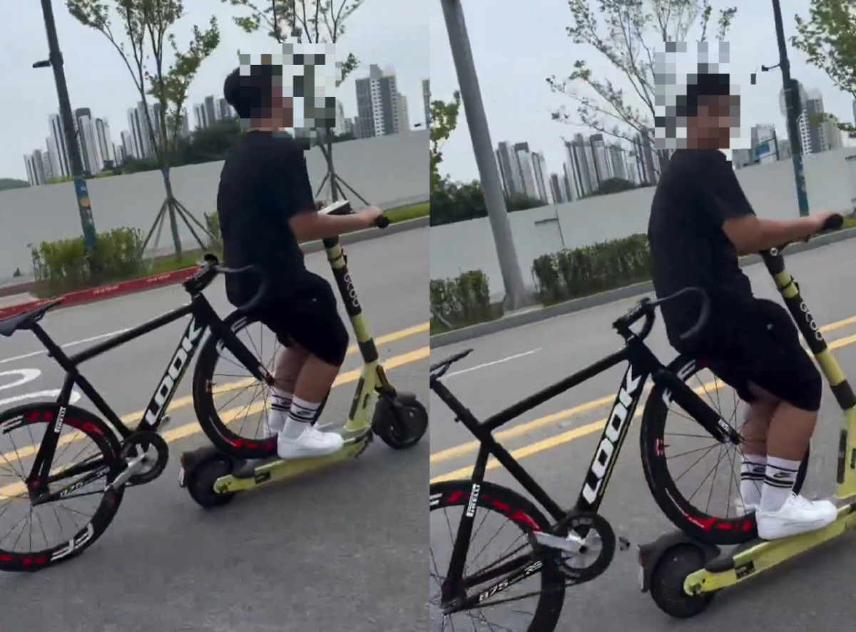전동킥보드 위에 자전거를 걸친 채 도로를 주행하는 남성의 모습이 포착돼 안전 불감증 논란이 일고 있다./사진=SNS 갈무리