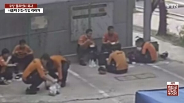 인천 쿠팡 물류센터 화재 현장 인근 주차장에서 소방관들이 바닥에 앉아 도시락으로 식사하고 있다./사진=YTN 뉴스 캡