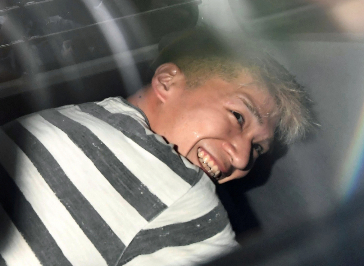 일본 도쿄의 사가미하라 장애인 시설 흉기 난동 사건의 범인 우에마쓰 사토시(植松聖·당시 26세)가 2016년 7월 27일 요코하마지방검찰청으로 송치되던 중 취재진들 앞에서 섬뜩한 미소를 보였다. /로이터=뉴스1