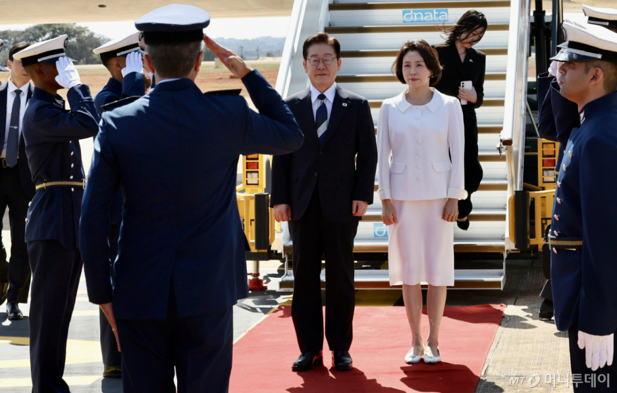 [브라질리아=뉴시스] 김진아 기자 = 이재명 대통령과 김혜경 여사가 26일(현지 시간) 브라질 브라질리아 공군기지에 도착해 경례를 받고 있다. 2026.07.27. bluesoda@newsis.com /사진=조성봉