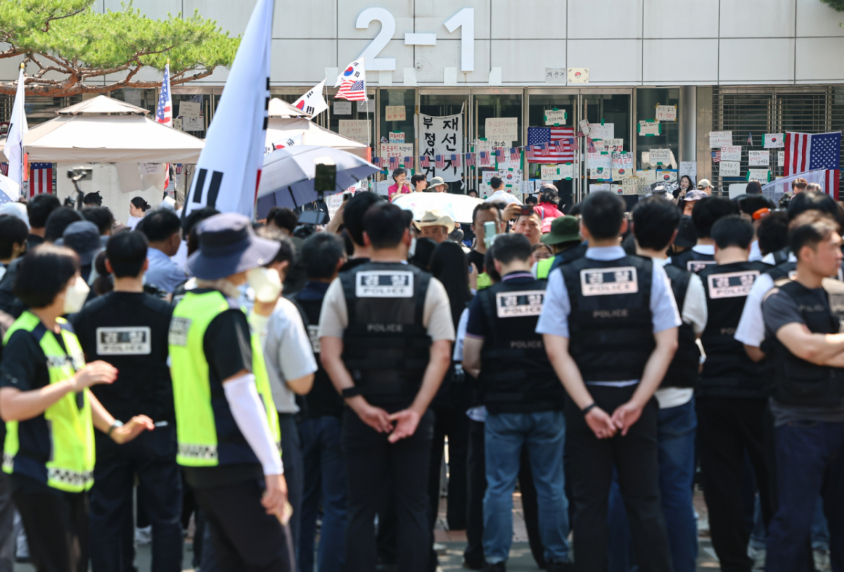 6·3 지방선거 '투표용지 부족 사태'로 12일째 잠실 개표소 봉쇄 시위가 이어지고 있는 16일 경찰과 대한체육회 등관계자들이 서울 송파구 올림픽공원 핸드볼경기장 진입을 시도하다 시위대와 대치하고 있다./사진=뉴스1. 
