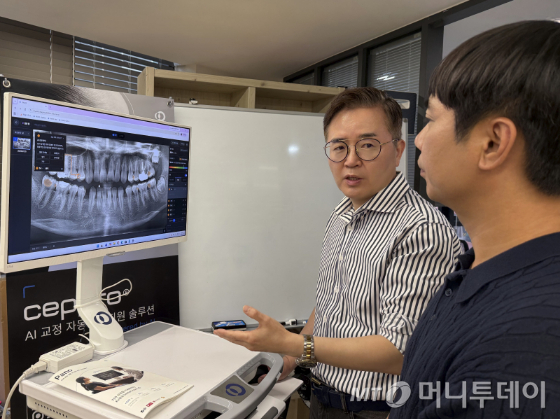 허수복 대표가 파노가 적용된 파노라마 영상 촬영물을 두고 설명하고 있다. 환자가 영상 위에 표시된 질환 의심 부위를 직접 확인하도록 해 진료에 대한 이해와 신뢰를 높이는 것이 핵심이다. /사진=머니투데이 