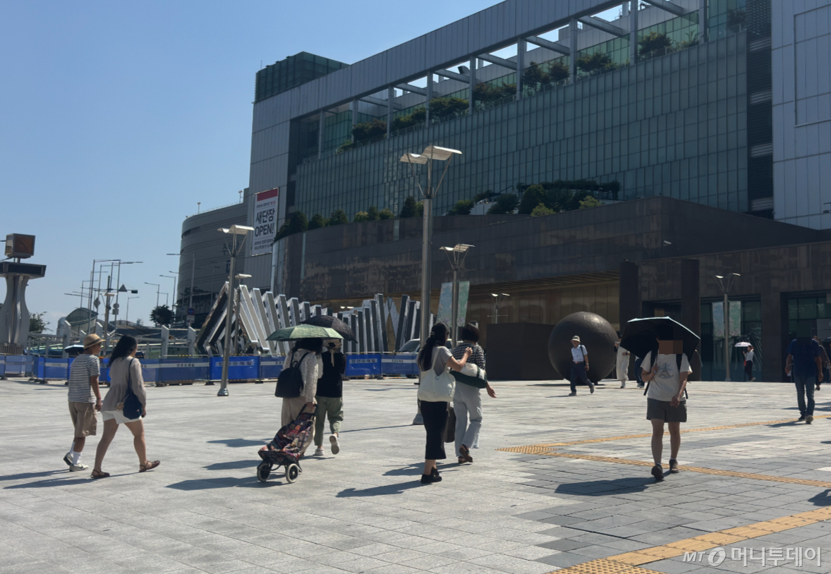 3일 낮 12시쯤 서울 동대문구 청량리역 광장에서 시민들이 양산으로 햇빛을 가린 채 지나고 있다./사진=최문혁 기자.