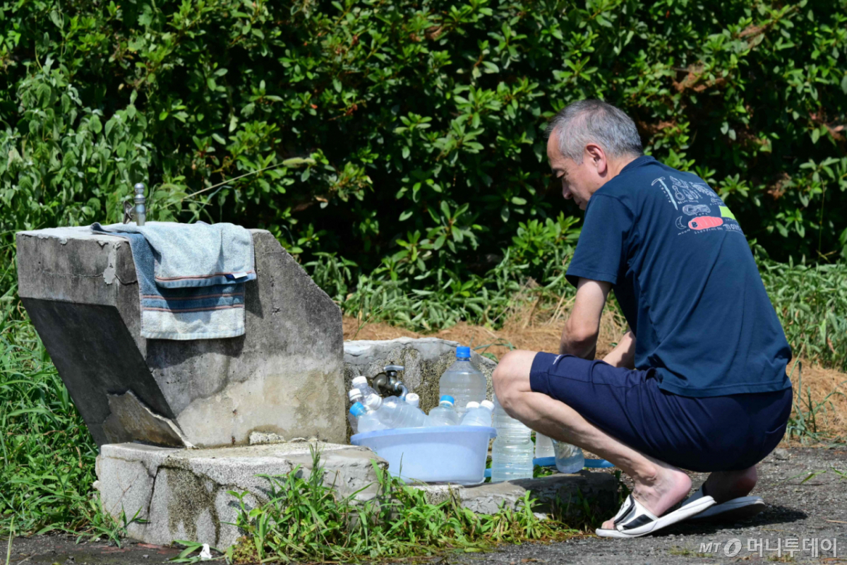 (야쓰시로 AFP=뉴스1) 권대옥 수습기자 = 30일 일본 구마모토현 야쓰시로시에서 강진 여파로 단수가 이어진 가운데 한 주민이 공원 수돗가에서 페트병에 물을 채우고 있다. 일본 기상청에 따르면 지난 28일 구마모토현에서 발생한 강진 이후 최고 기온 35도에 달하는 폭염이 이어지고 있다. 2026.07.30 ⓒ AFP=뉴스1 Copyright © 뉴스1. All rights reserved. 무단 전재 및 재배포, AI학습 이용 금지. /사진=(야쓰시로 AFP=뉴스1) 권대옥 수습기자
