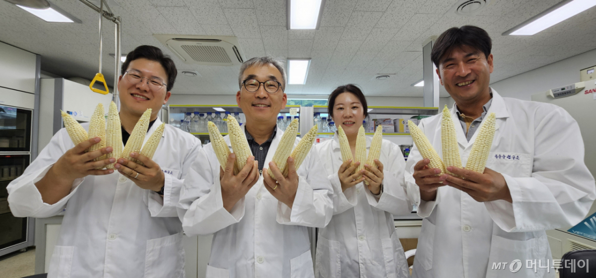 류시환 옥수수연구소장이 연구소 관계자들과 함께 옥수수를 들고 환하게 웃고 있다. /사진=정혁수