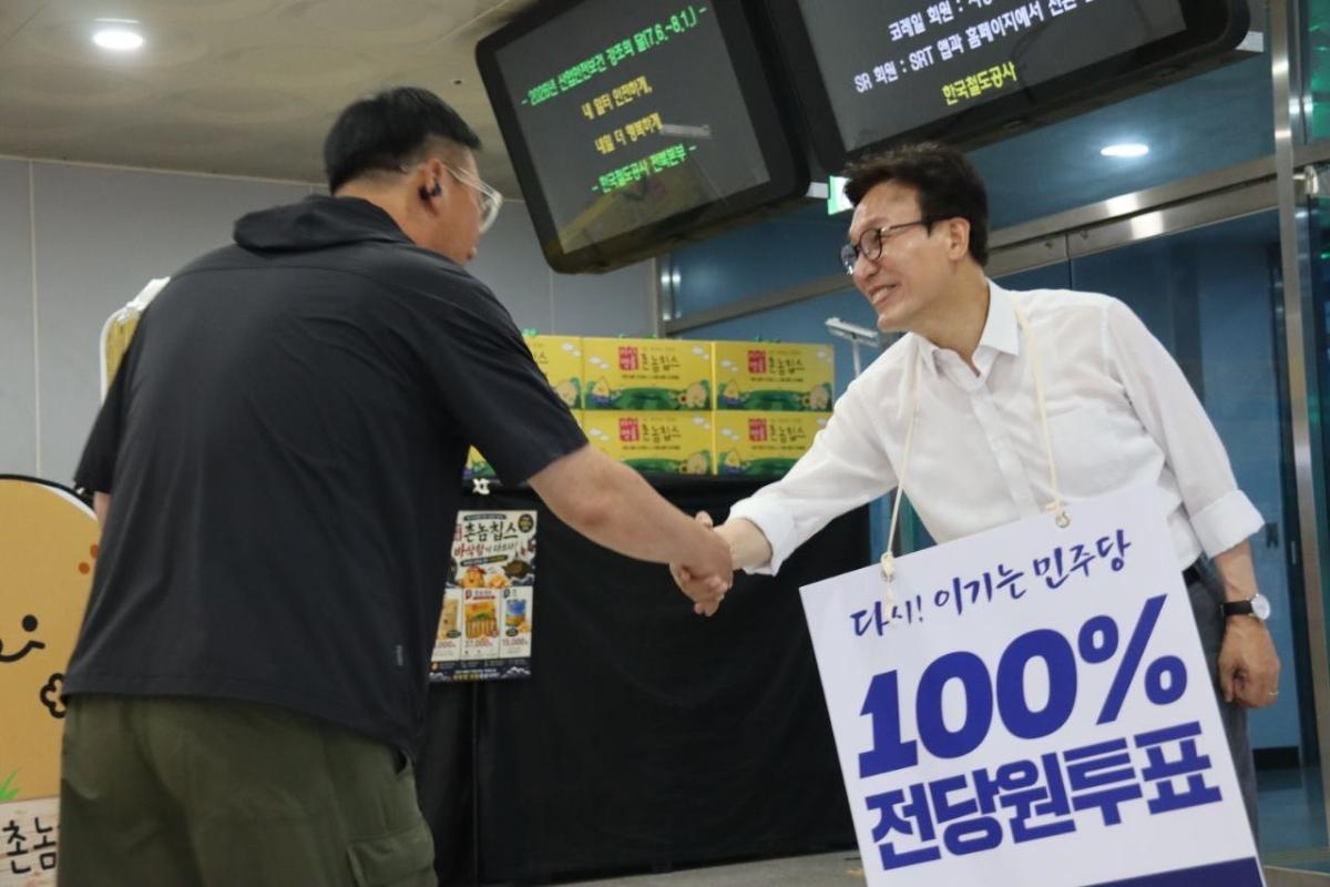 김민석 당대표 후보가 이른 새벽 익산역에서 '100% 전당원 투표'를 호소하는 피킷을 건채 시민들을 만나고 있다. /사진=독자제공