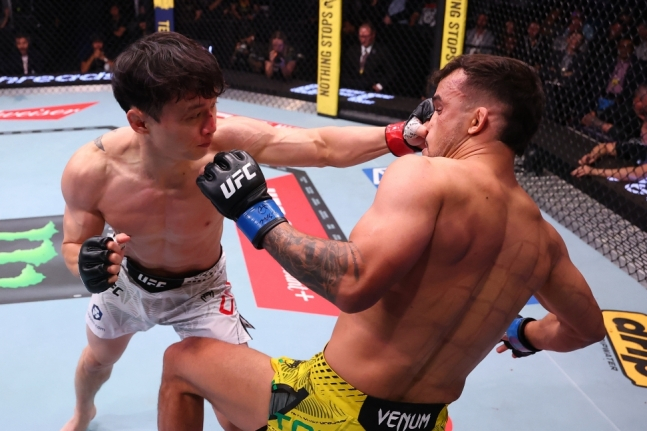 최두호(왼쪽)가 지난 5월 다니엘 산토스와 대결에서 왼손 훅을 적중시키고 있다. /사진=UFC 제공