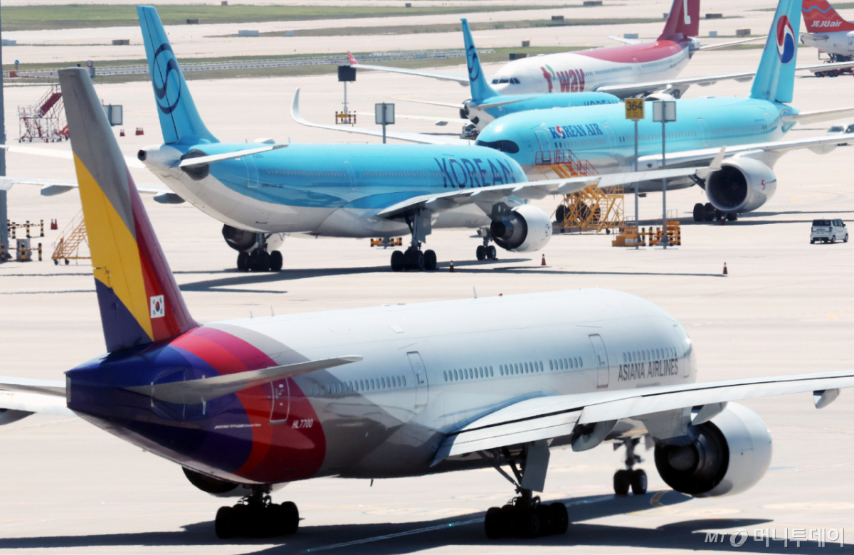 [인천공항=뉴시스] 박주성 기자 = 아시아나항공이 임시주주총회를 열고 대한항공과 합병 체결을 가결한 12일 인천국제공항 제2여객터미널 활주로에 대한항공과 아시아나 항공기가 이동하고 있다. 2026.08.12. park7691@newsis.com /사진=