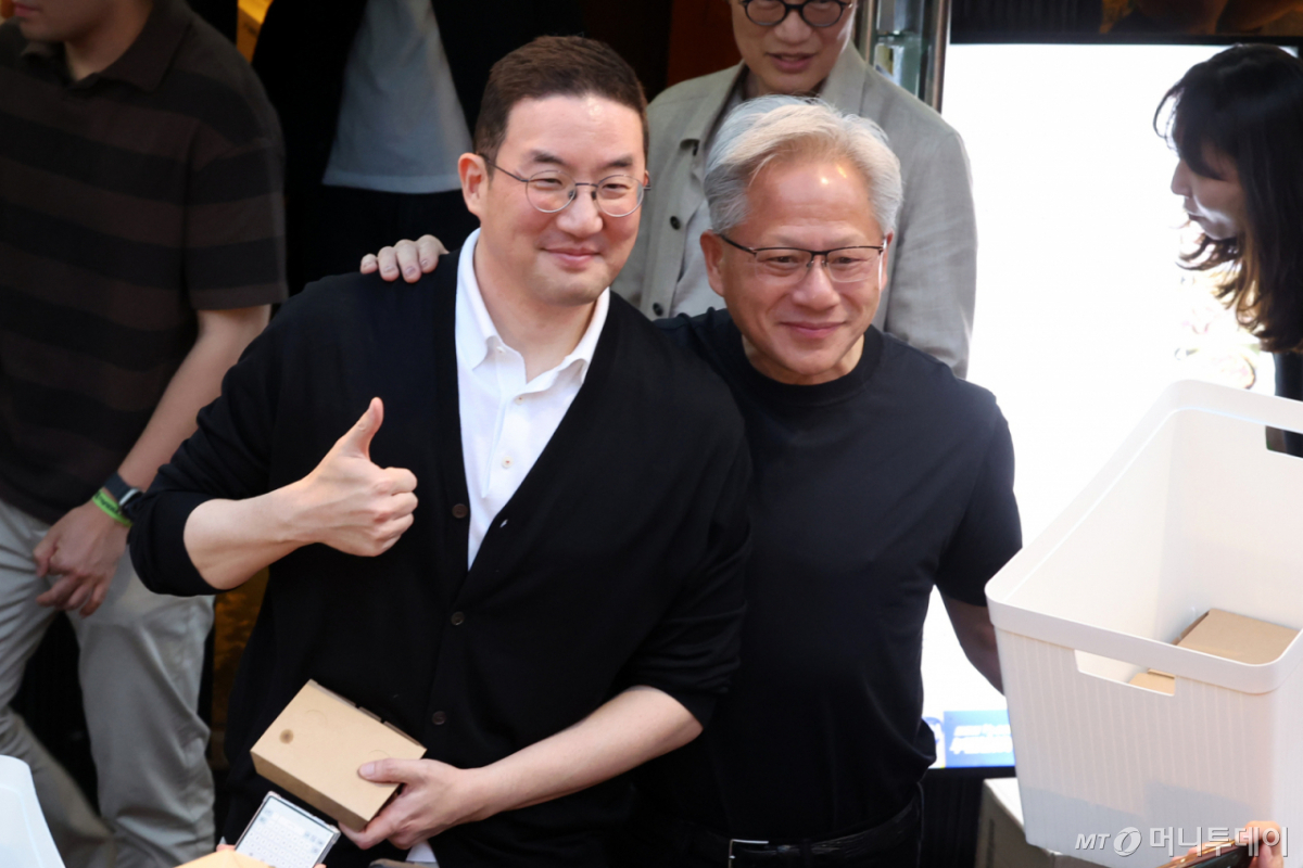 [서울=뉴시스] 조성우 기자 = 젠슨 황 엔비디아 최고경영자(CEO)가 5일 서울 마포구 홍대 인근의 한 고깃집에서 최태원 SK그룹 회장과 구광모 LG그룹 회장, 이해진 네이버 의장과 이른바 '삼소(삼겹살·소주) 회동' 도중 시민들에게 간식을 나눠주다 포즈를 취하고 있다. 2026.06.05. xconfind@newsis.com /사진=조성우