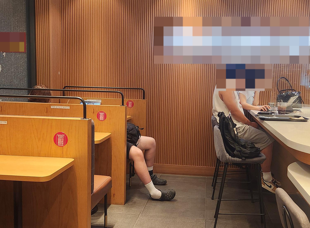 한 카페에 남성으로 추정되는 손님이 소파에 아예 드러누워 휴식을 취하는 모습. /사진=온라인 커뮤니티 갈무리